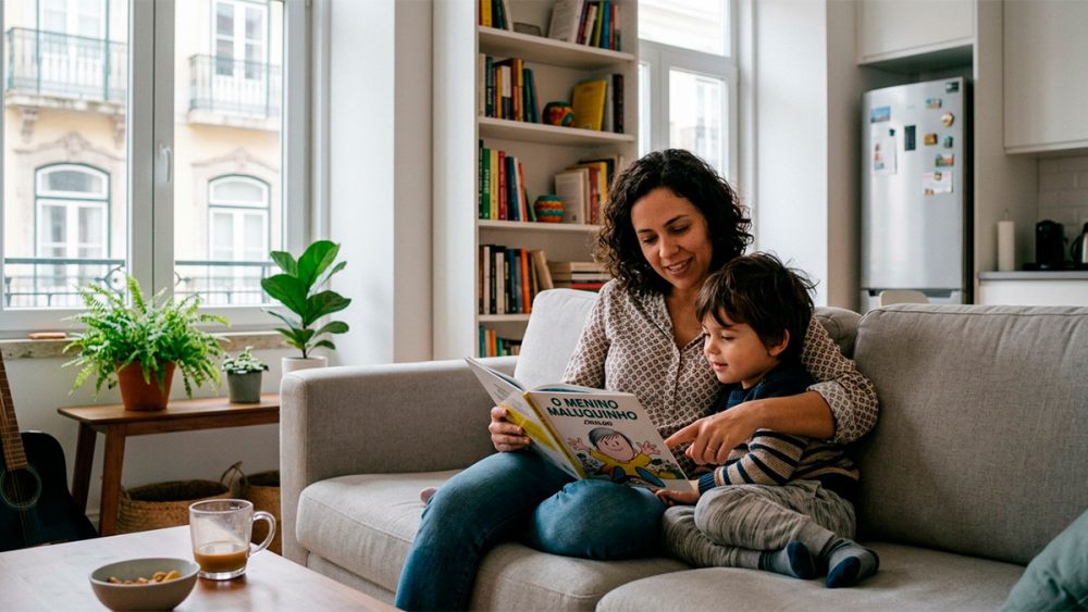 Mãe morando fora do Brasil lendo para o filho em apartamento aconchegante.